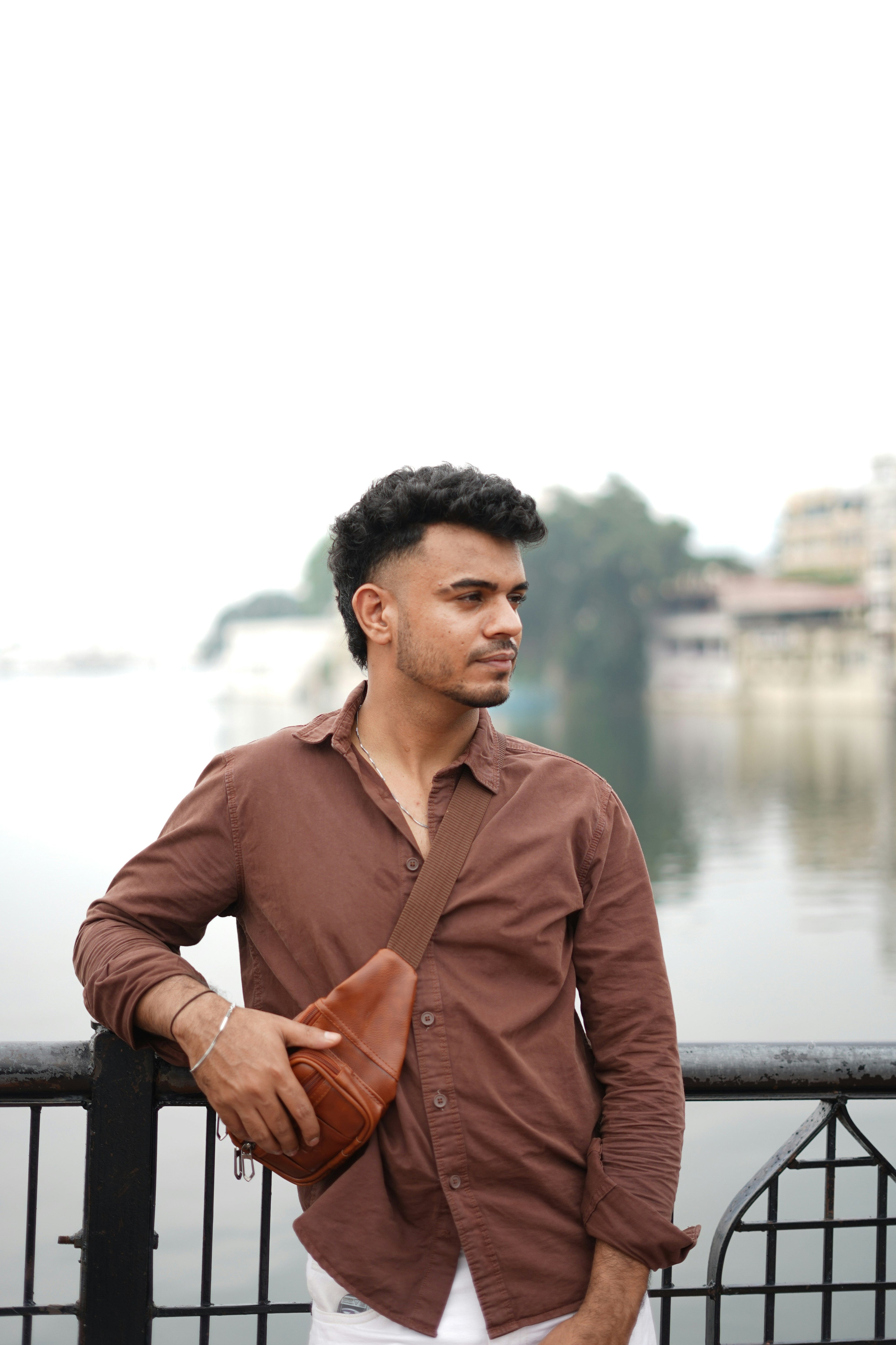 Man wearing brown shirt with leather crossbody bag, casual men street style fashion
